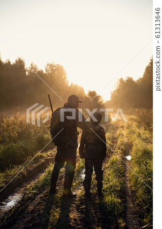 Father teaches his grandson to hunt in a woods Father teaches his grandson to hunt in a woods 61313646