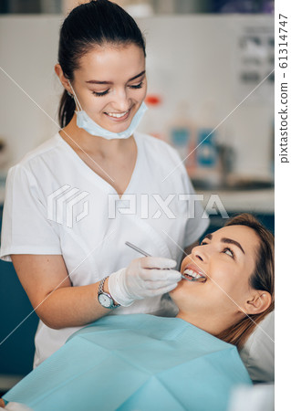 friendly dentist woman treating patient friendly dentist woman treating patient 61314747