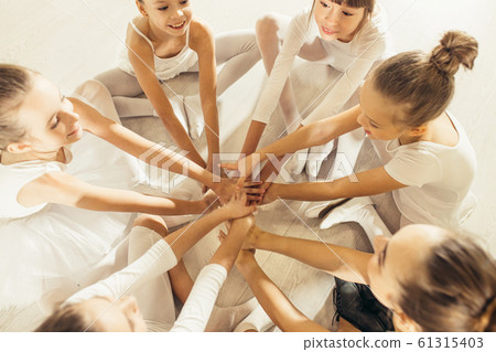 top view on young ballerinas sitting on floor together 61315403