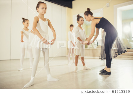 young professional ballerina practicing and teaching children young professional ballerina practicing and teaching children 61315559