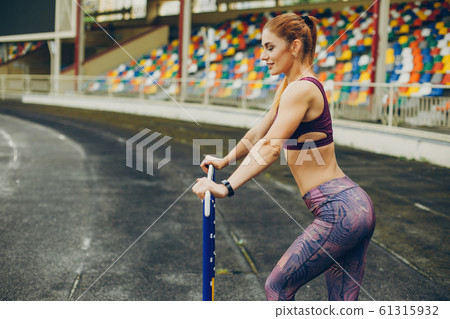The girl at the stadium is playing sports 61315932