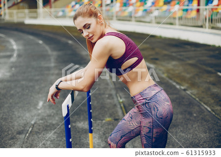 The girl at the stadium is playing sports 61315933