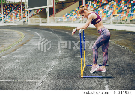 The girl at the stadium is playing sports The girl at the stadium is playing sports 61315935