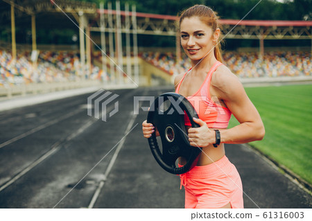 The girl at the stadium is playing sports The girl at the stadium is playing sports 61316003