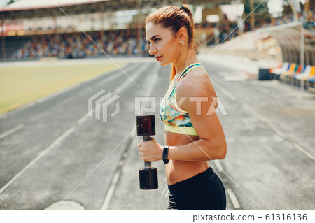 The girl at the stadium is playing sports The girl at the stadium is playing sports 61316136