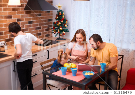 young parents and children have meal in kitchen young parents and children have meal in kitchen 61316479