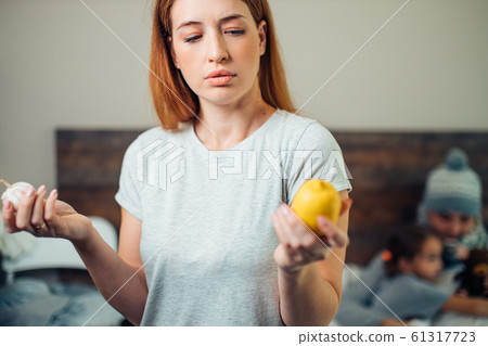 young caucasian woman holding lemon and garlic in hands, ill family 61317723