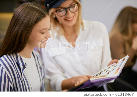 young caucasian hairdresser at work with client 61318467