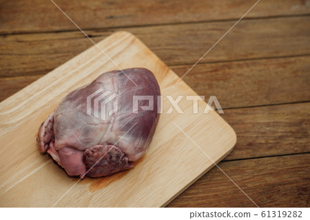 Fresh pig heart on wooden cutting board Fresh pig heart on wooden cutting board 61319282