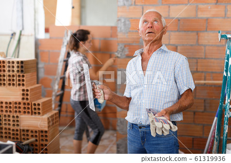 Elderly man controlling construction Elderly man controlling construction 61319936