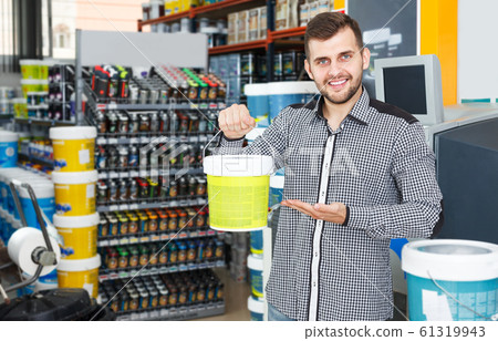 Man holding bucket of paint in store Man holding bucket of paint in store 61319943