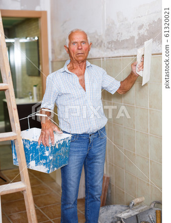 Elderly man with spatula and plaster Elderly man with spatula and plaster 61320021