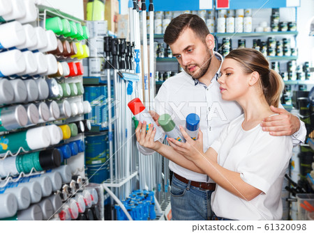 Couple choosing paint spray in shop 61320098
