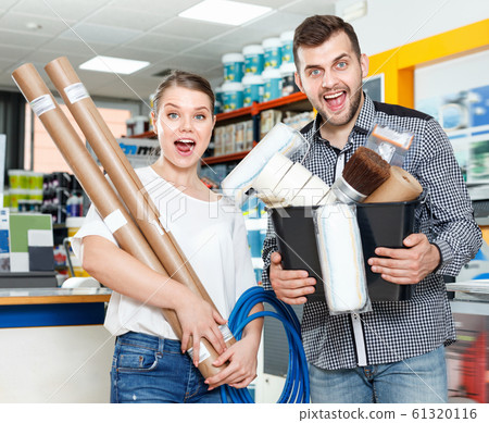 Couple standing with variety instruments for repair house in the store Couple standing with variety instruments for repair house in the store 61320116