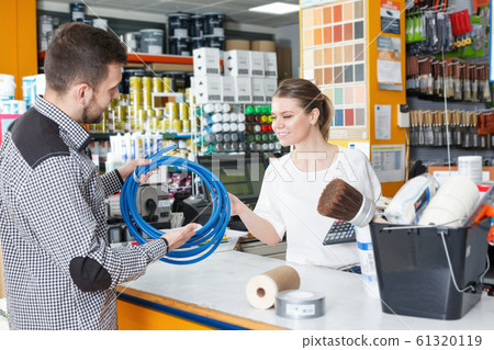 Girl seller helping man customer at the counter 61320119