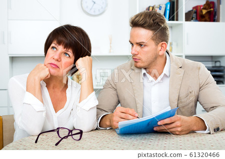 Mother and son sign documents 61320466