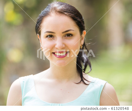 cheerful smiling young woman portrait in outdoors 61320548