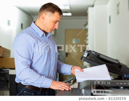 Businessman working with printer in the office 61320559