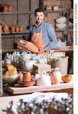 man potter holding ceramic vessels in atelier man potter holding ceramic vessels in atelier 61320560