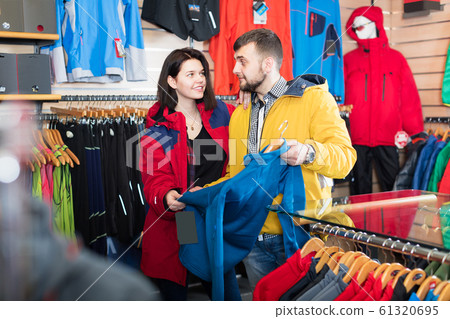 Couple choosing jacket in store Couple choosing jacket in store 61320695