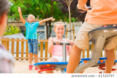 Company of kids are teetering on the swing Company of kids are teetering on the swing 61320797