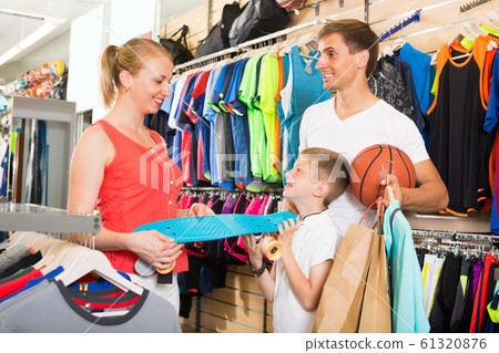 Family of three choosing skateboard in store. 61320876