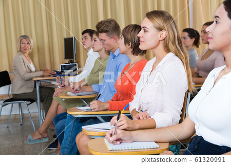 Side view of student group with female teacher on lecture 61320991