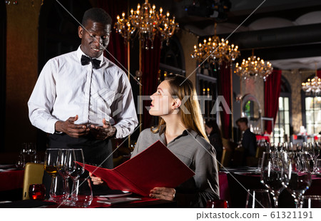 African-american waiter receiving order from guest in fashionable restaurant 61321191