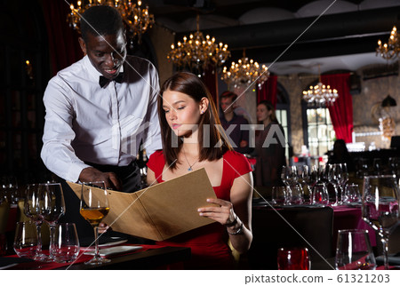 African-american waiter receiving order from guest in fashionable restaurant African-american waiter receiving order from guest in fashionable restaurant 61321203