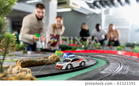 Toy remote control racing cars on the track and enthusiastic players 61321591