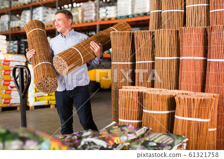 Man buying braided wooden fence 61321758