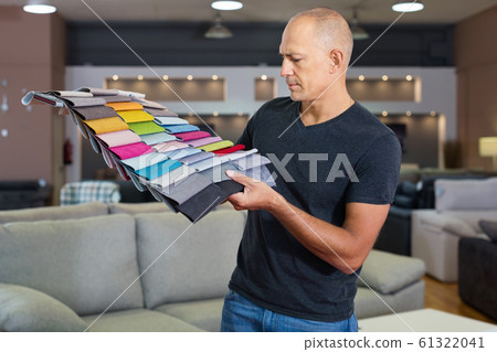 Portrait of man showing various samples of textures for furniture in shop Portrait of man showing various samples of textures for furniture in shop 61322041