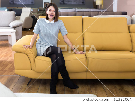 Woman testing sofa in furniture store Woman testing sofa in furniture store 61322064