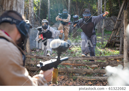 People playing paintball outdoors People playing paintball outdoors 61322082