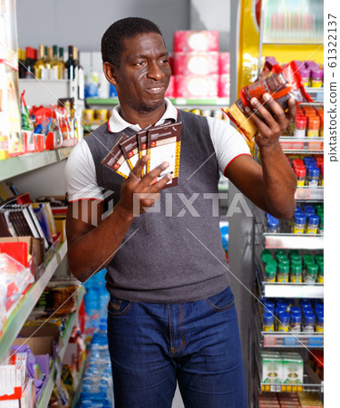 Portrait of Afro man buying chocolate sweets in store 61322137