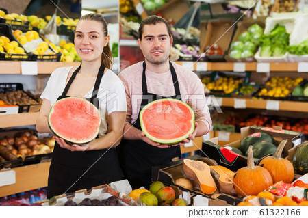 Glad woman and man holding half of watermelon Glad woman and man holding half of watermelon 61322166