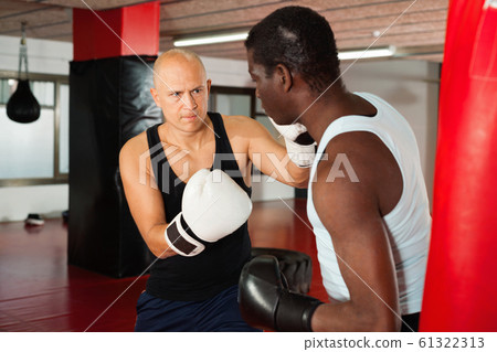 Sparring two boxers in the gym. Battle of two boxers Sparring two boxers in the gym. Battle of two boxers 61322313