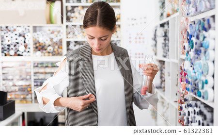 Woman choosing buttons in shop Woman choosing buttons in shop 61322381