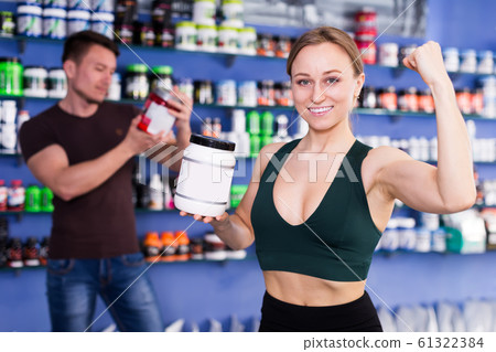 female with a jar of sports nutrition showing muscles female with a jar of sports nutrition showing muscles 61322384