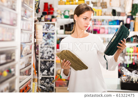 Seamstress looking for ribbons in haberdasher shop Seamstress looking for ribbons in haberdasher shop 61322475