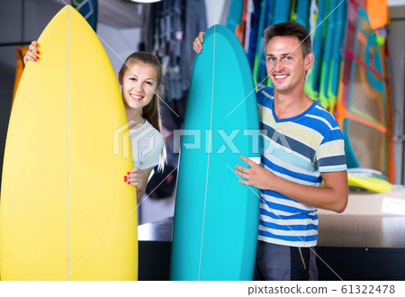 couple is demonstraiting surfboard in nautical shop. couple is demonstraiting surfboard in nautical shop. 61322478