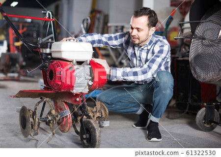 Professional worker is starting to work with plough 61322530