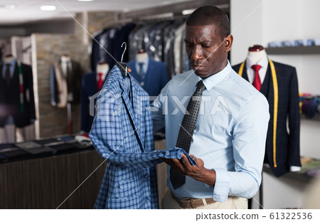 Male tailor demonstrating of fashionable suit in apparel shop Male tailor demonstrating of fashionable suit in apparel shop 61322536