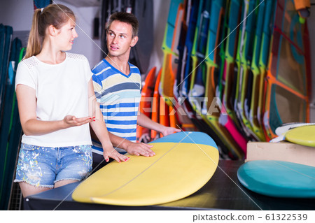 couple is choosing surfboard in nautical shop. couple is choosing surfboard in nautical shop. 61322539