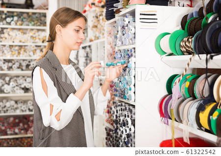 Woman choosing buttons in shop Woman choosing buttons in shop 61322542