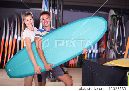 couple is posing in surfboard store on the beach. couple is posing in surfboard store on the beach. 61322583