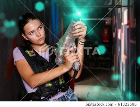 Smiling girl took aim during laser tag game Smiling girl took aim during laser tag game 61322596