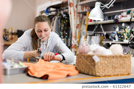 Smiling woman professional working with material at atelier Smiling woman professional working with material at atelier 61322647