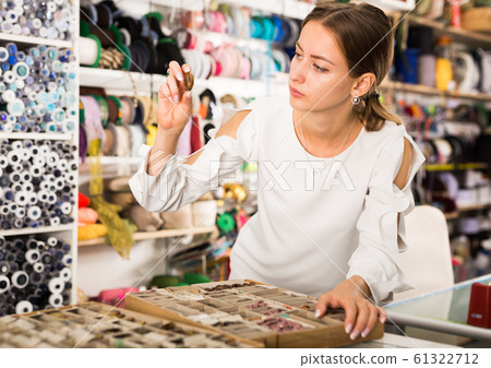 Woman choosing buttons in needlecraft store Woman choosing buttons in needlecraft store 61322712