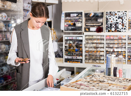 Woman choosing buttons in shop Woman choosing buttons in shop 61322715